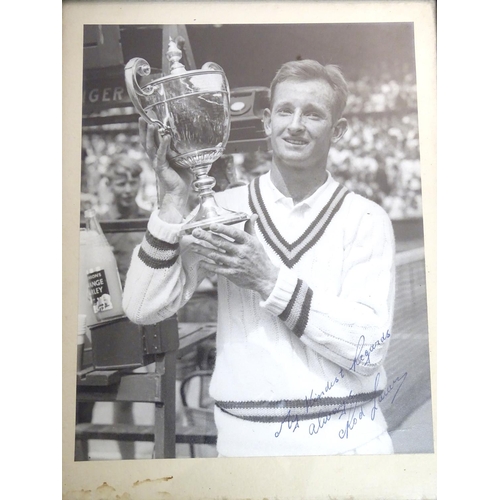 139 - Tennis: A  signed black and white photograph depicting the Australian tennis player Rod Laver holdin... 