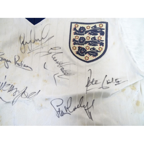 147 - Football: A Child's size 1986 England shirt, signed by: Bobby Robson , Peter Beardsley , Gary Lineke... 