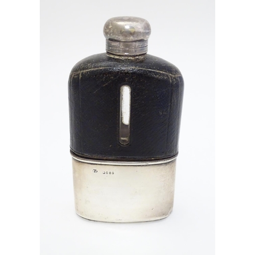 202 - A glass hip flask with half leather covering and silver beaker to lower half, hallmarked London 1875... 