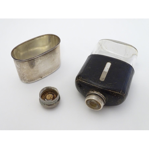 202 - A glass hip flask with half leather covering and silver beaker to lower half, hallmarked London 1875... 