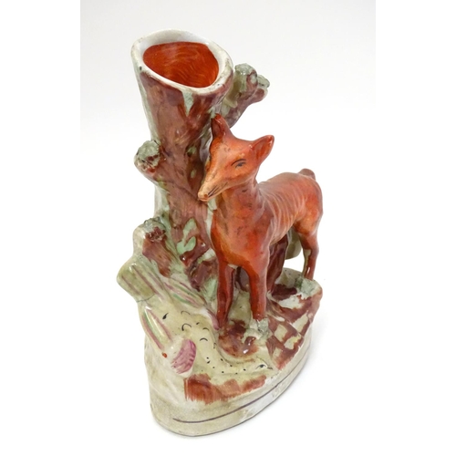 212 - A Staffordshire flat backed fox and game bird spill vase, 8'' high, 5 1/2'' wide