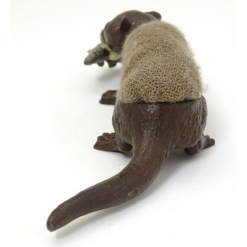 214 - A 21stC novelty pen wipe / pin cushion, formed as a cold painted otter with fish in its mouth. Appro... 