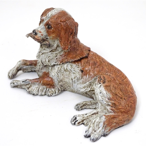 216 - A 21stC novelty cold painted bronze inkwell formed as a recumbent dog with feather to mouth, and hea... 