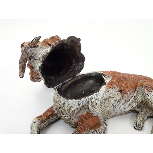 216 - A 21stC novelty cold painted bronze inkwell formed as a recumbent dog with feather to mouth, and hea... 