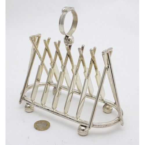 217 - A 21stC silver plate novelty toast rack, formed with crossed cricket bat decoration and stumps to ei... 