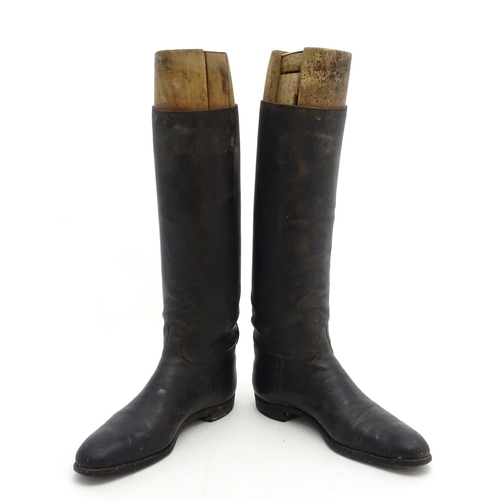 296 - An old pair of gentleman's black leather riding boots, together with trees. The boots approx size 11