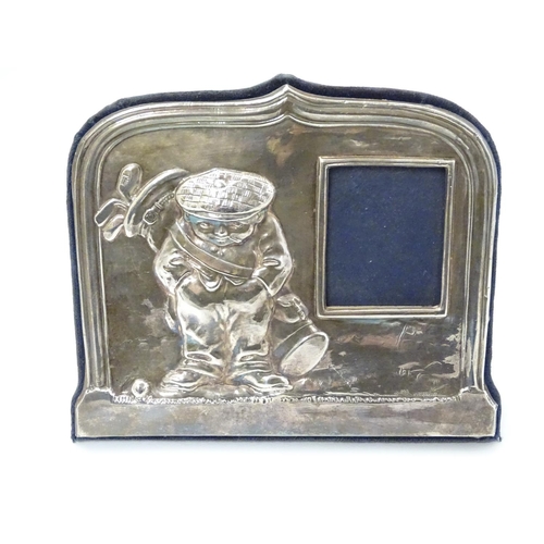 326 - A silver photograph frame having comical golfing figure decoration to one side. Hallmarked Sheffield... 