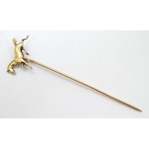 326A - A gold and yellow metal stick pin surmounted by a horse. Marked 10k. Approx 2 3/4'' long overall