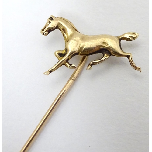 326A - A gold and yellow metal stick pin surmounted by a horse. Marked 10k. Approx 2 3/4'' long overall