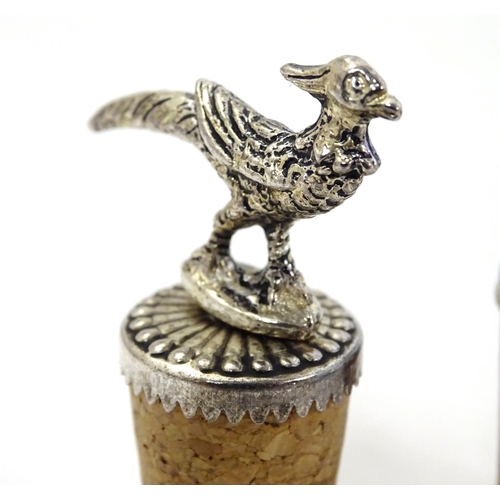 385 - 2 cork bottle stoppers, surmounted by silver plate decoration of a pheasant and a boar. Each approx ... 