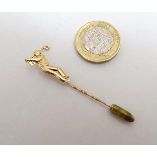 395 - A gilt metal stick pin surmounted by a golfer