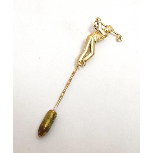 395 - A gilt metal stick pin surmounted by a golfer