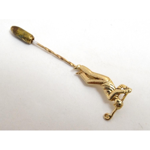 395 - A gilt metal stick pin surmounted by a golfer