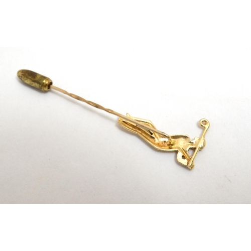 395 - A gilt metal stick pin surmounted by a golfer