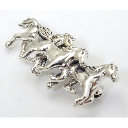 398 - A brooch with 3 galloping horse decoration. Marked '925' 1 3/4'' wide