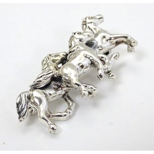 398 - A brooch with 3 galloping horse decoration. Marked '925' 1 3/4'' wide