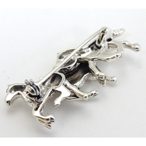 398 - A brooch with 3 galloping horse decoration. Marked '925' 1 3/4'' wide