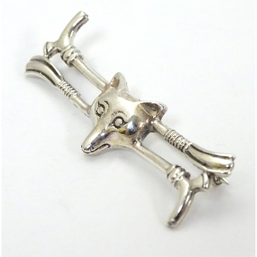 405 - A brooch with riding crops and fox head decoration. Approx 1 3/4'' wide