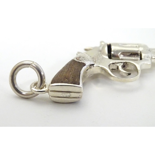 415 - A pendant formed as a hand gun / revolver. 21stC .  2 1/4'' long