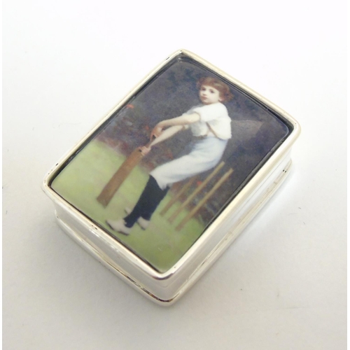 444 - A pill box with enamel decoration to top depicting a young boy playing cricket, approx 1 1/4'' x 1''... 