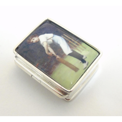 444 - A pill box with enamel decoration to top depicting a young boy playing cricket, approx 1 1/4'' x 1''... 