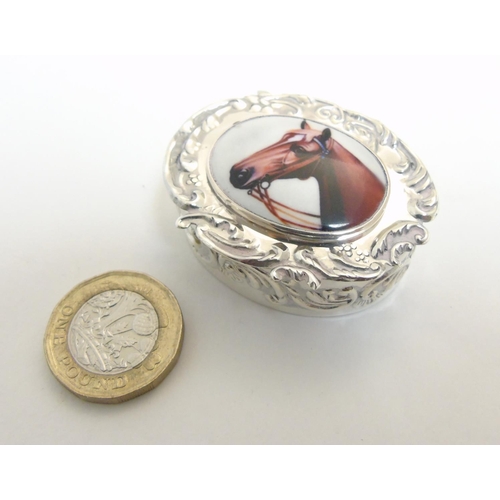 450 - A pill box of ovoid form having enamel cabochon to lid, depicting a horses head, 1 3/4'' x 1 1/2'' x... 