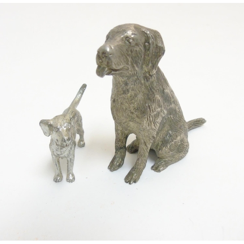 455 - A cast silver plate model of a dog standing together with another, formed as a seated dog. The  larg... 