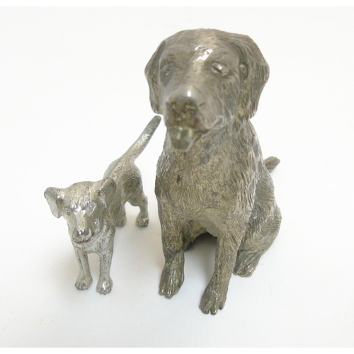 455 - A cast silver plate model of a dog standing together with another, formed as a seated dog. The  larg... 