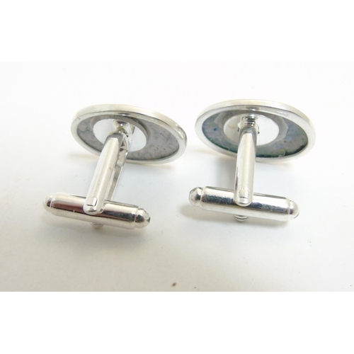 456 - A pair of cufflinks having oval cabochon with golfer decoration