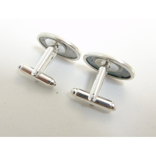 456 - A pair of cufflinks having oval cabochon with golfer decoration