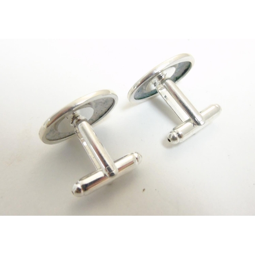 456 - A pair of cufflinks having oval cabochon with golfer decoration