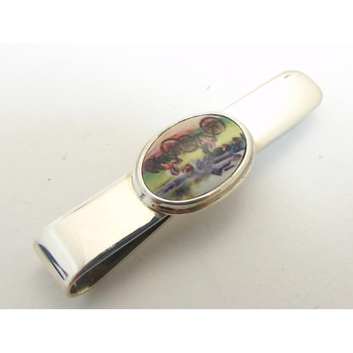 462 - A tie clip having enamel cabochon to centre decorated with cyclists. Approx 2 1/4'' long