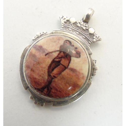 472 - A silver fob having later applied enamel cabochon decoration depicting a golfer. Approx 1 1/4'' high