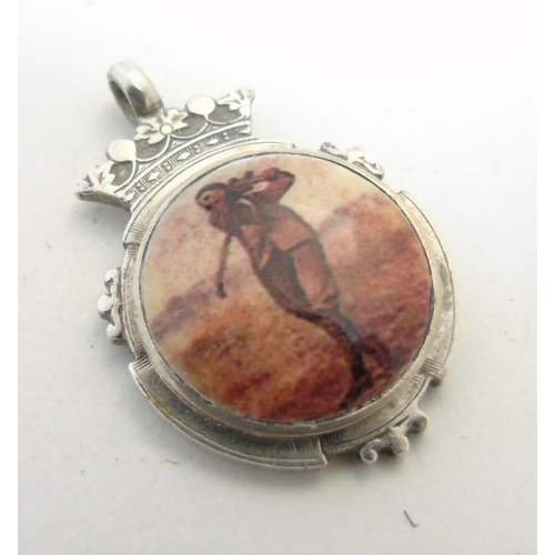 472 - A silver fob having later applied enamel cabochon decoration depicting a golfer. Approx 1 1/4'' high