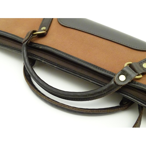 491 - Shooting: A Brady-type canvas and leather gunslip with wool lining, having shoulder strap and reinfo... 