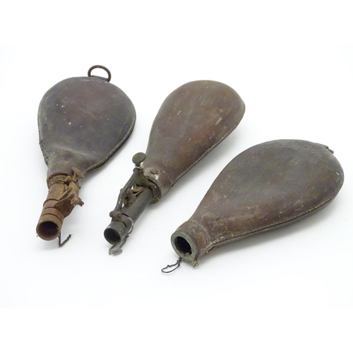 515 - Shooting: Two 19thC leather and brass shot flasks, with leaf spring opening plugs, together with the... 