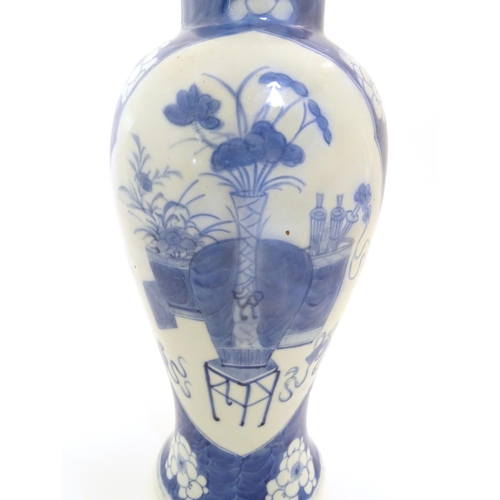 10 - A Chinese, blue and white baluster vase decorated with prunus flowers, the central decoration displa... 