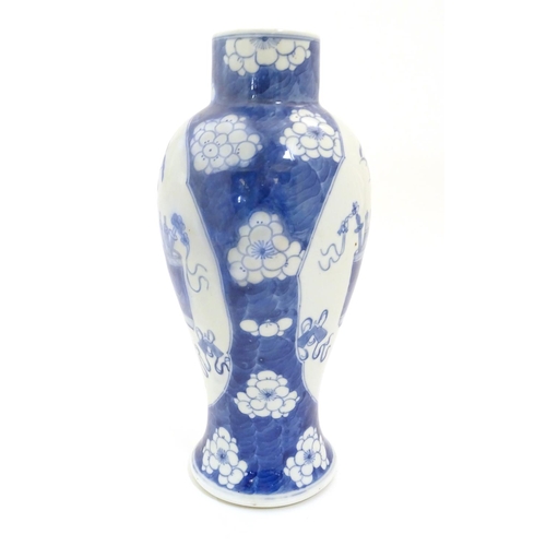 10 - A Chinese, blue and white baluster vase decorated with prunus flowers, the central decoration displa... 