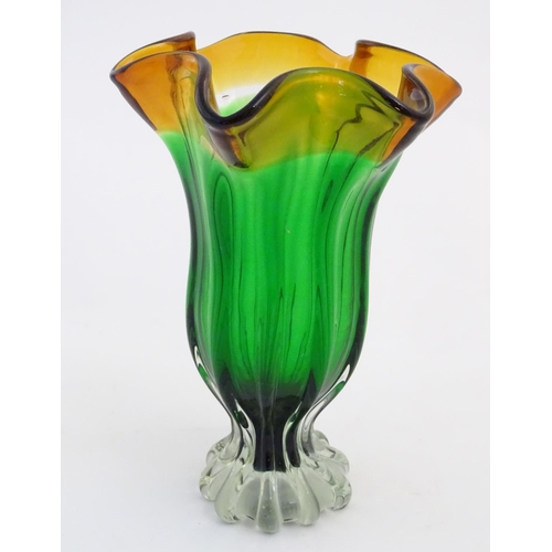 102 - Glass : a mid 20thC Studio glass vase with fluted wavy rim, green body, clear foot and Amber top, ha... 