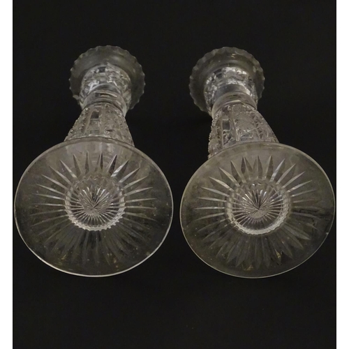 111 - Glass : a pair of cut glass candlesticks with hobnail like decoration and star cut decoration to und... 