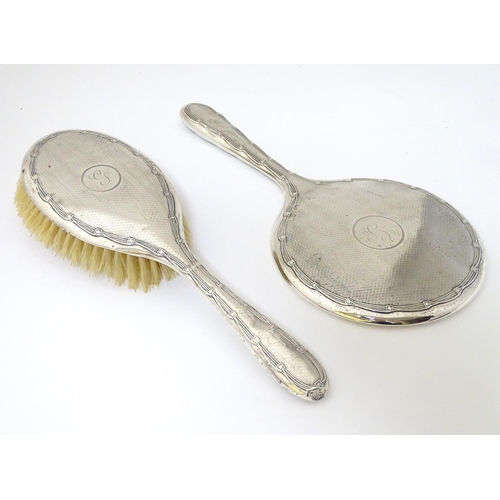 126 - A silver backed hand mirror and brush with engine turned decoration. Hallmarked Birmingham 1911/12  ... 