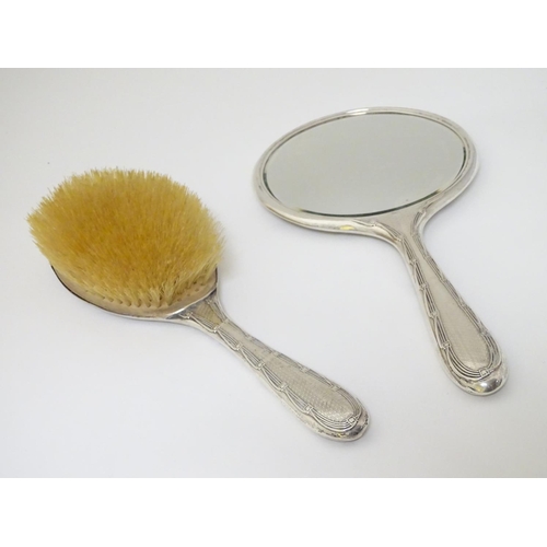 126 - A silver backed hand mirror and brush with engine turned decoration. Hallmarked Birmingham 1911/12  ... 