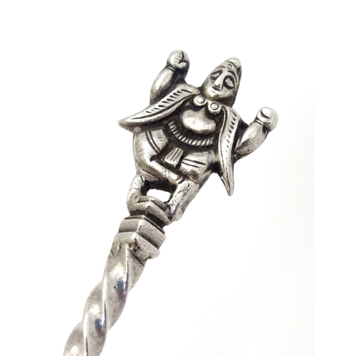 142 - A white metal spoon with engraved bowl and twist handle surmounted by a deity / Buddha. 5 3/4'' long