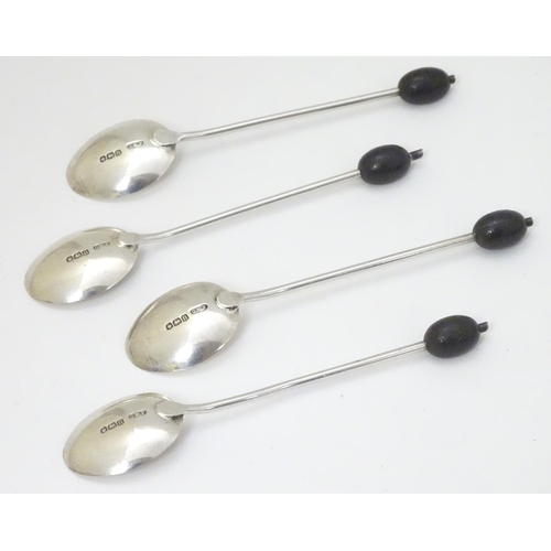 147 - 4 silver coffee spoons hallmarked Sheffield 1930 maker C W Fletcher & Son Ltd the handle surmounted ... 