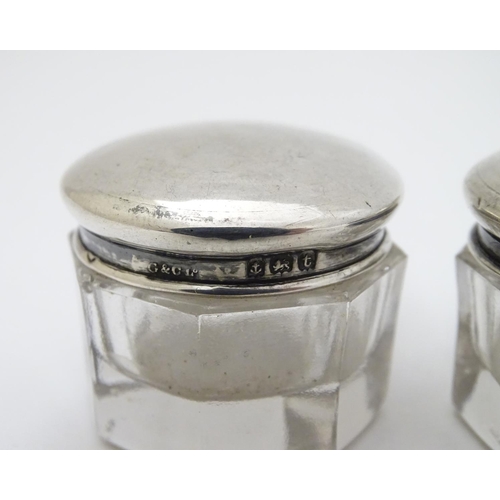 150 - A pair of glass pots with silver tops hallmarked Birmingham 1918 maker G & C Ltd. 1 1/4'' wide