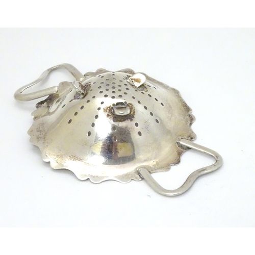 152 - A silver tea strainer and stand hallmarked Sheffield 1920 maker E J Houlston. 4 1/4'' wide (74g) (2)