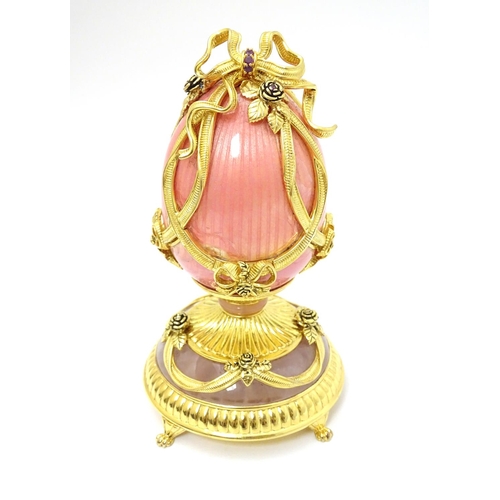 159 - Franklin Mint : A silver gilt model of a Faberge egg ' The Faberge Rose Bouquet ' with pink enamel d... 