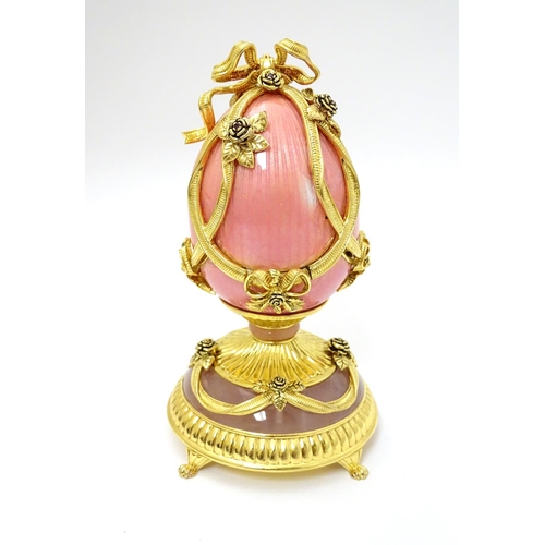 159 - Franklin Mint : A silver gilt model of a Faberge egg ' The Faberge Rose Bouquet ' with pink enamel d... 