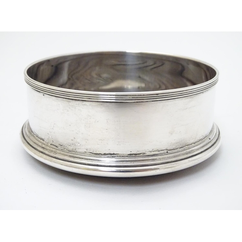 171 - A silver bottle coaster with turned wooden base. Hallmarked London 1991 maker J A Campbell. Approx 4... 