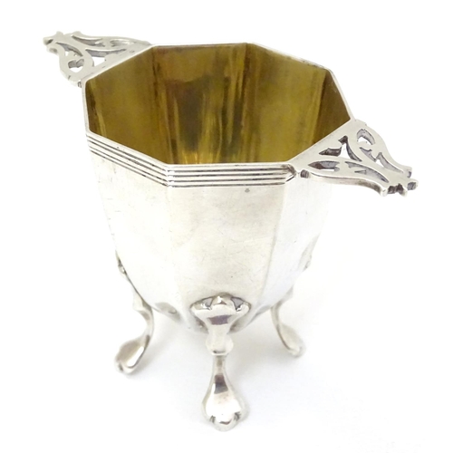 173 - A silver octagonal formed salt / pepper base with twin handles and gilded interior. Hallmarked Londo... 